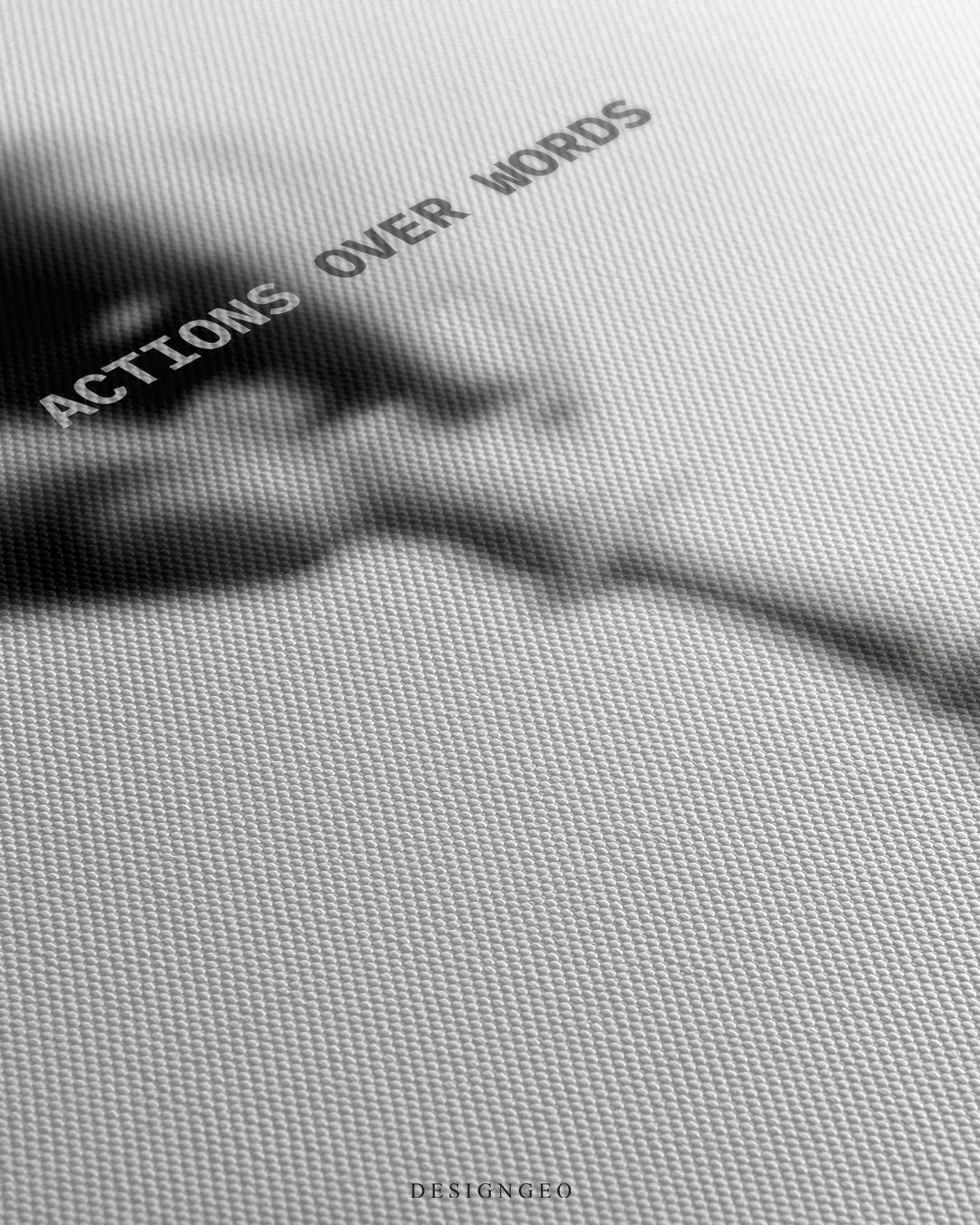 Angled detailed macro texture of white canvas print showing blurred hand playing chess piece next to king silhouette with Actions Over Words quote