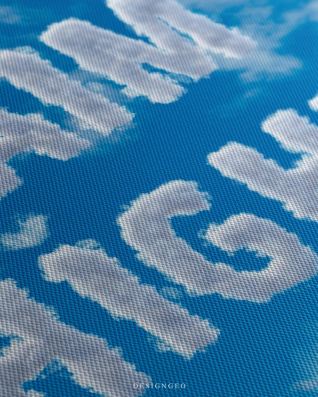 Angled close-up detail shot highlighting the realistic cloud texture of the letters and the fine woven canvas fabric grain
