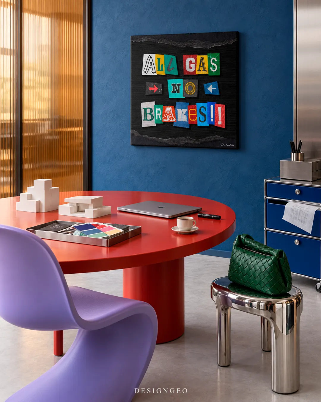 Modern executive office interior featuring a square canvas print with colorful ransom note letters spelling ALL GAS NO BRAKES mounted on a blue wall above a red conference table