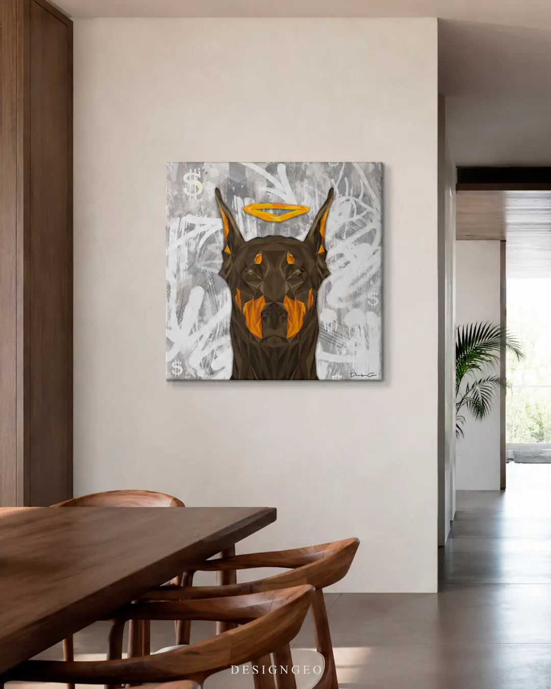 Square Angel Doberman street art canvas print mounted on a beige wall above a dark wooden dining table and matching chairs in a bright modern home