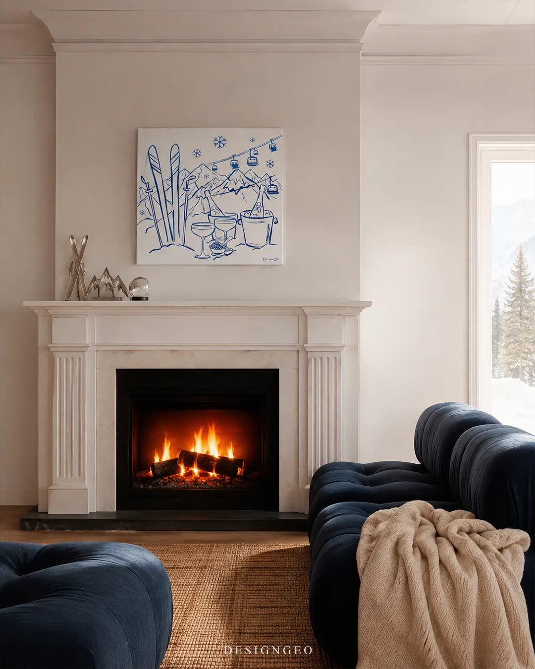 Square blue après-ski canvas wall art mounted above a classic white fireplace mantel in a modern chalet living room with a navy blue sofa and snowy forest window view