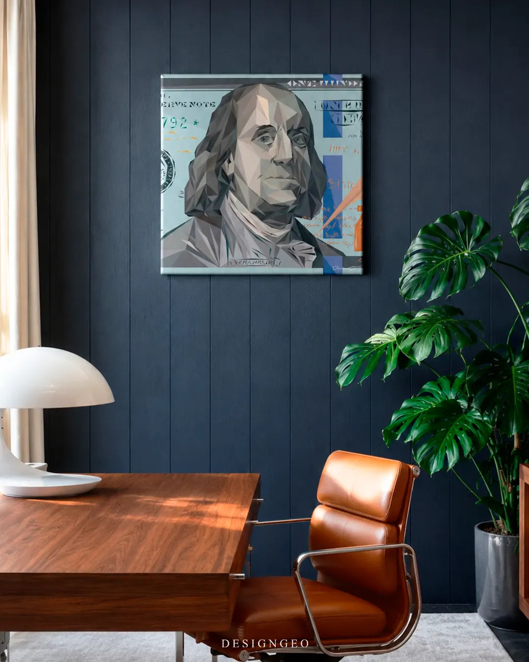 Square geometric 100 dollar bill canvas wall art mounted on a dark blue wood panel wall in an executive office with a cognac leather chair, wooden desk, and Monstera plant
