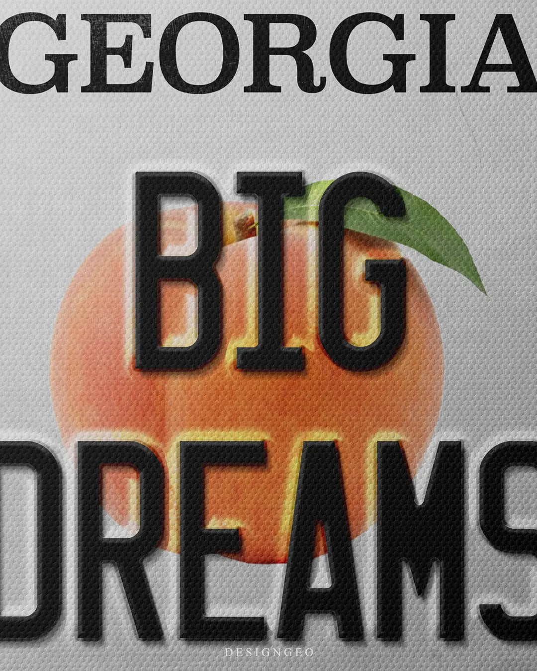 Medium shot showing black embossed BIG DREAMS typography over a realistic Georgia peach graphic with green leaf on a light gray metal background