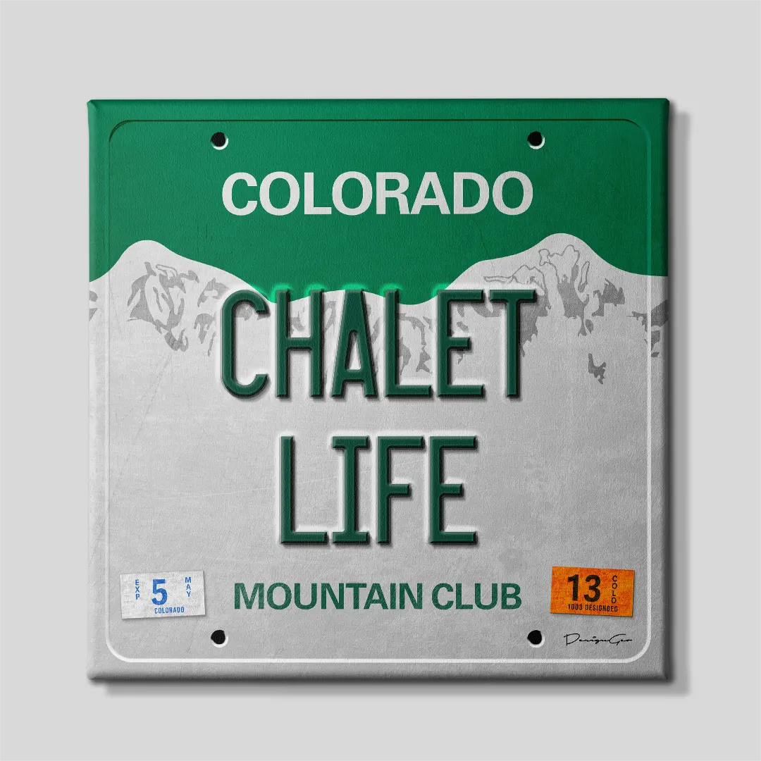 Front view of a square motivational canvas print styled as a retro Colorado license plate featuring dark green CHALET LIFE lettering, snowy Rocky Mountain graphics, and MOUNTAIN CLUB slogan