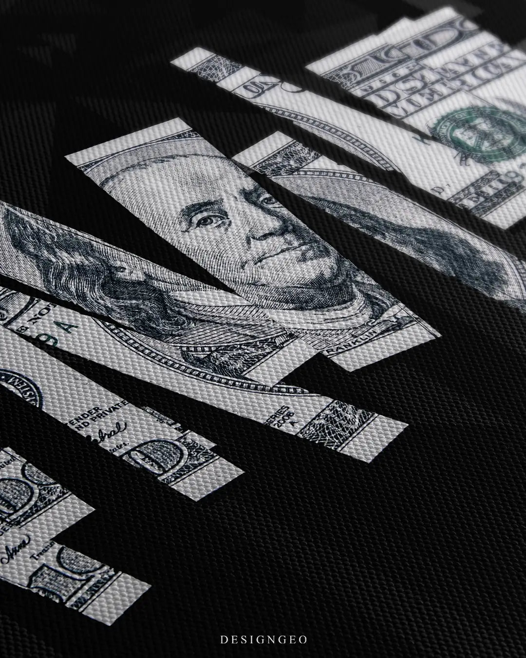 Close-up of modern money-themed wall art featuring a sliced US dollar bill with sharp, clean edges on a solid black background