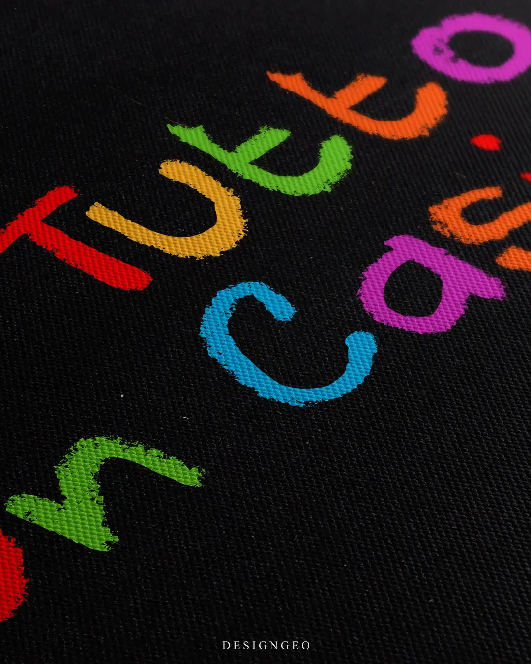Angled macro close-up of the premium black canvas texture, showcasing the textured multicolored brushstroke typography of the Italian phrase "È Tutto Un Casino"