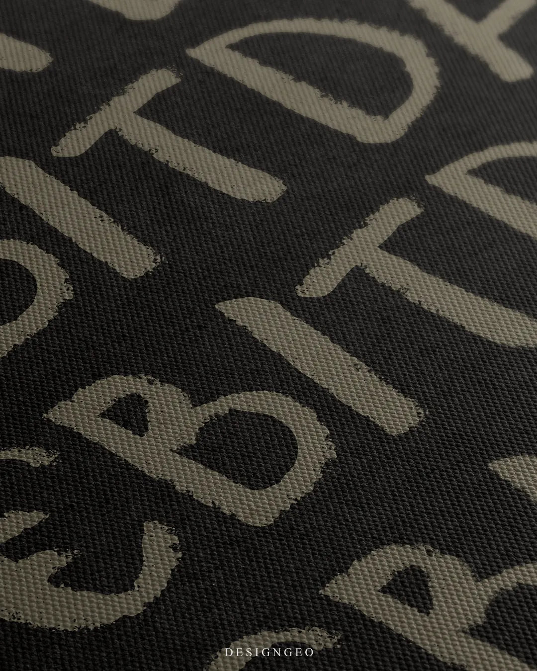 Angled macro shot detailing the fine woven matte canvas grain and the distressed edge details of the beige EBITDA typography