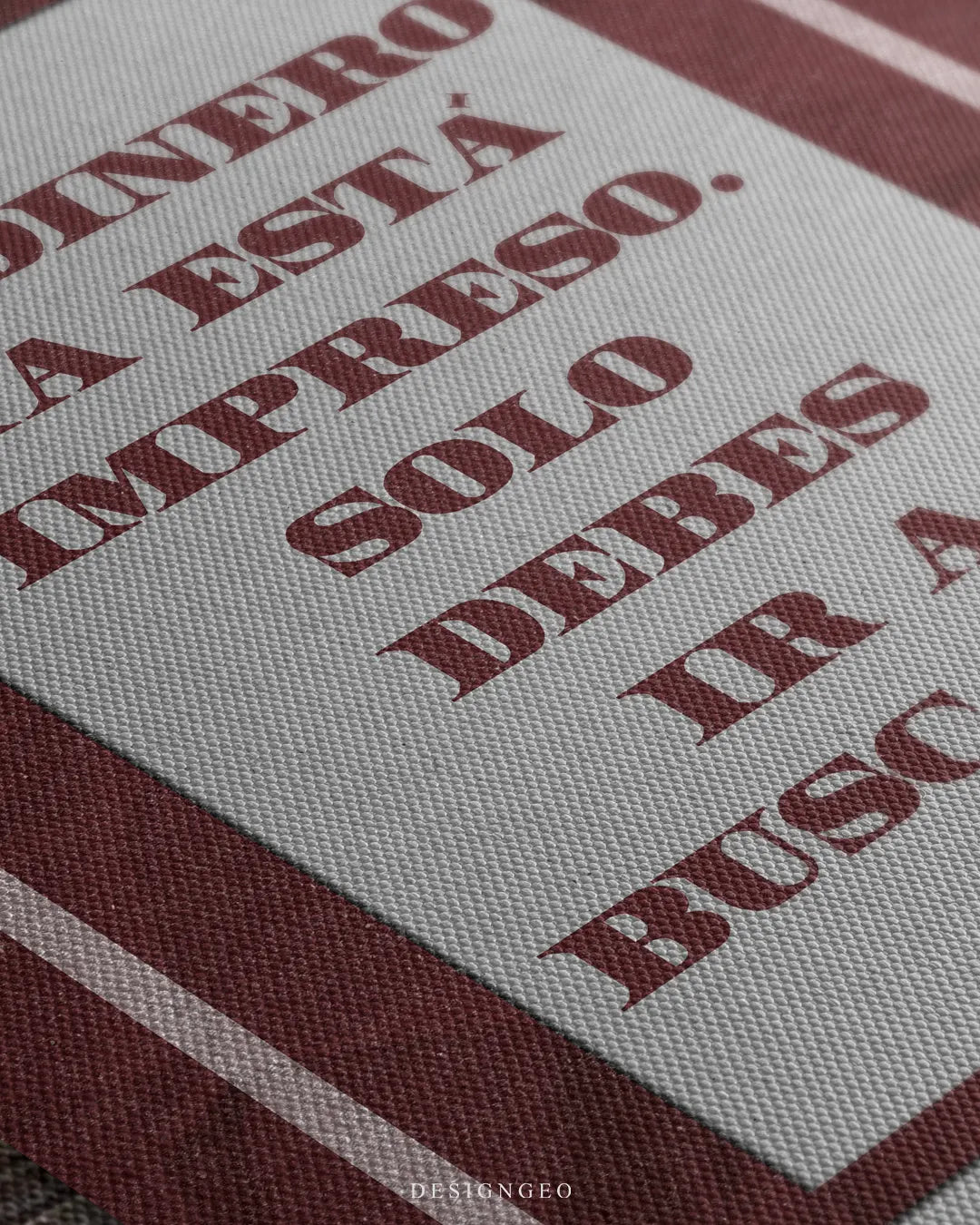 Detailed macro texture of woven canvas print showing Mexican pesos money band with Spanish quote El Dinero Ya Esta Impreso Solo Debes Ir A Buscarlo