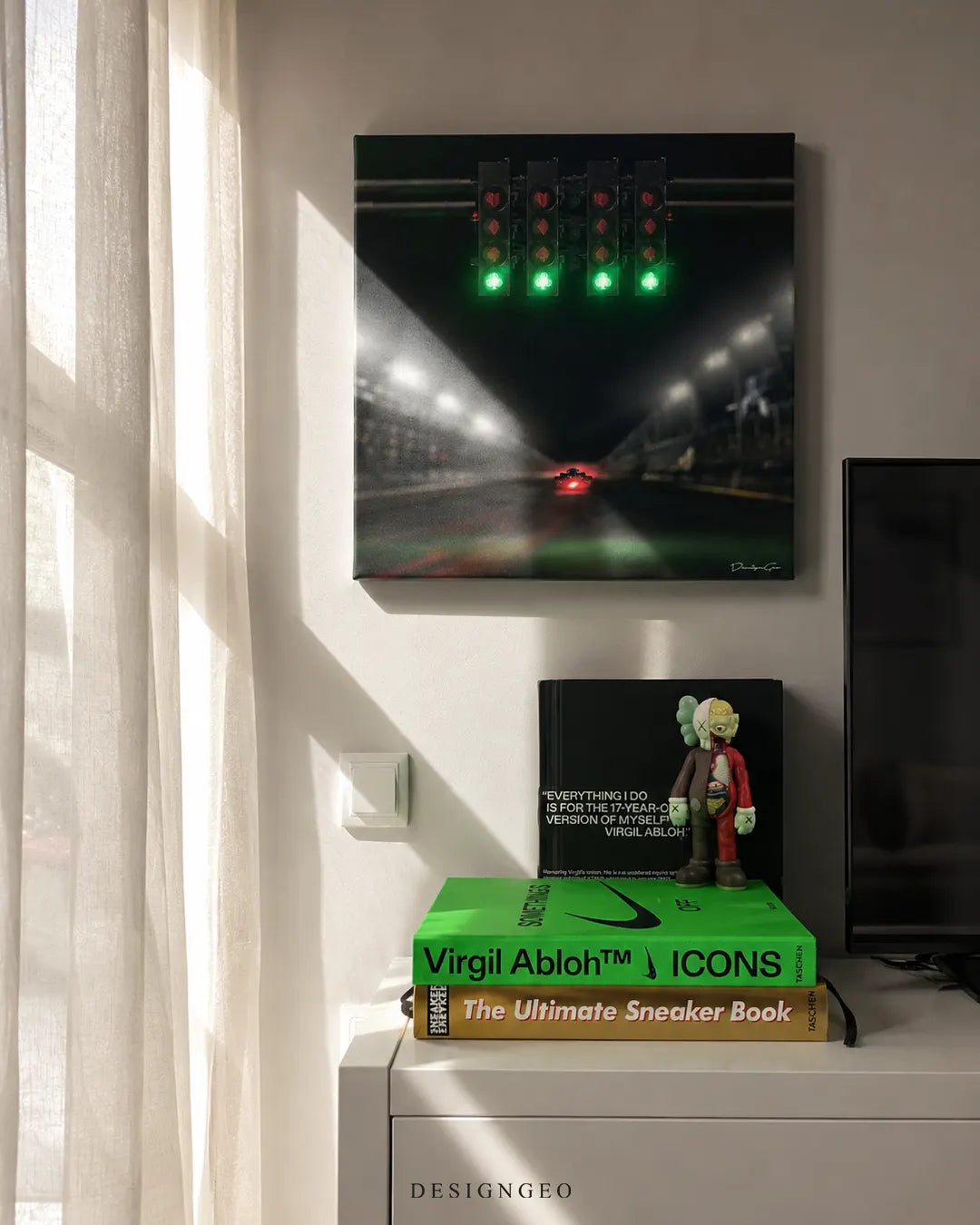 Square F1 starting lights canvas print mounted on a white wall above a cabinet with Virgil Abloh design books and an anatomical KAWS Companion figure