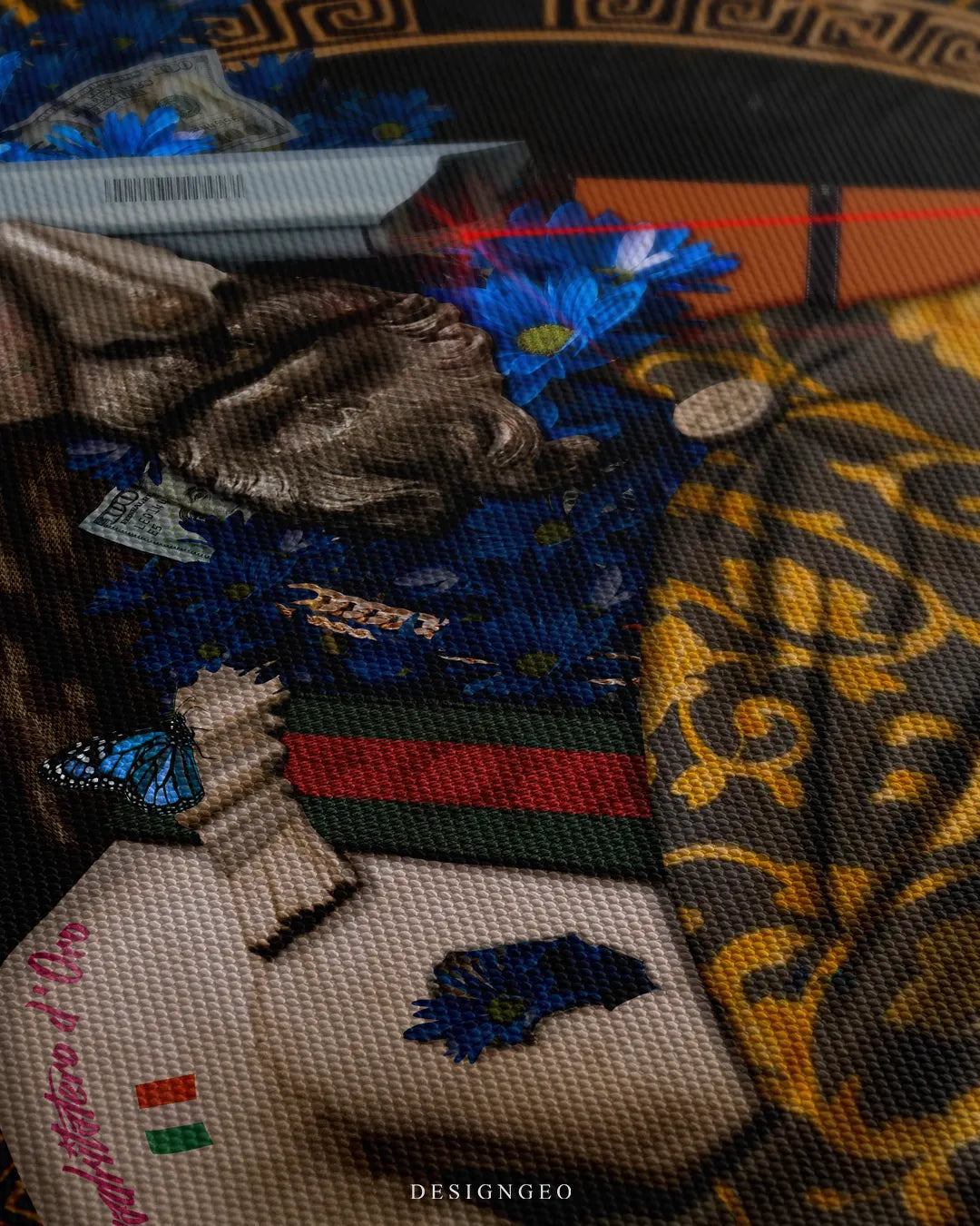 Angled extreme macro view highlighting the woven canvas surface texture, golden baroque damask pattern, red and green designer stripe accent, blue butterfly, and Italian typography tattoo