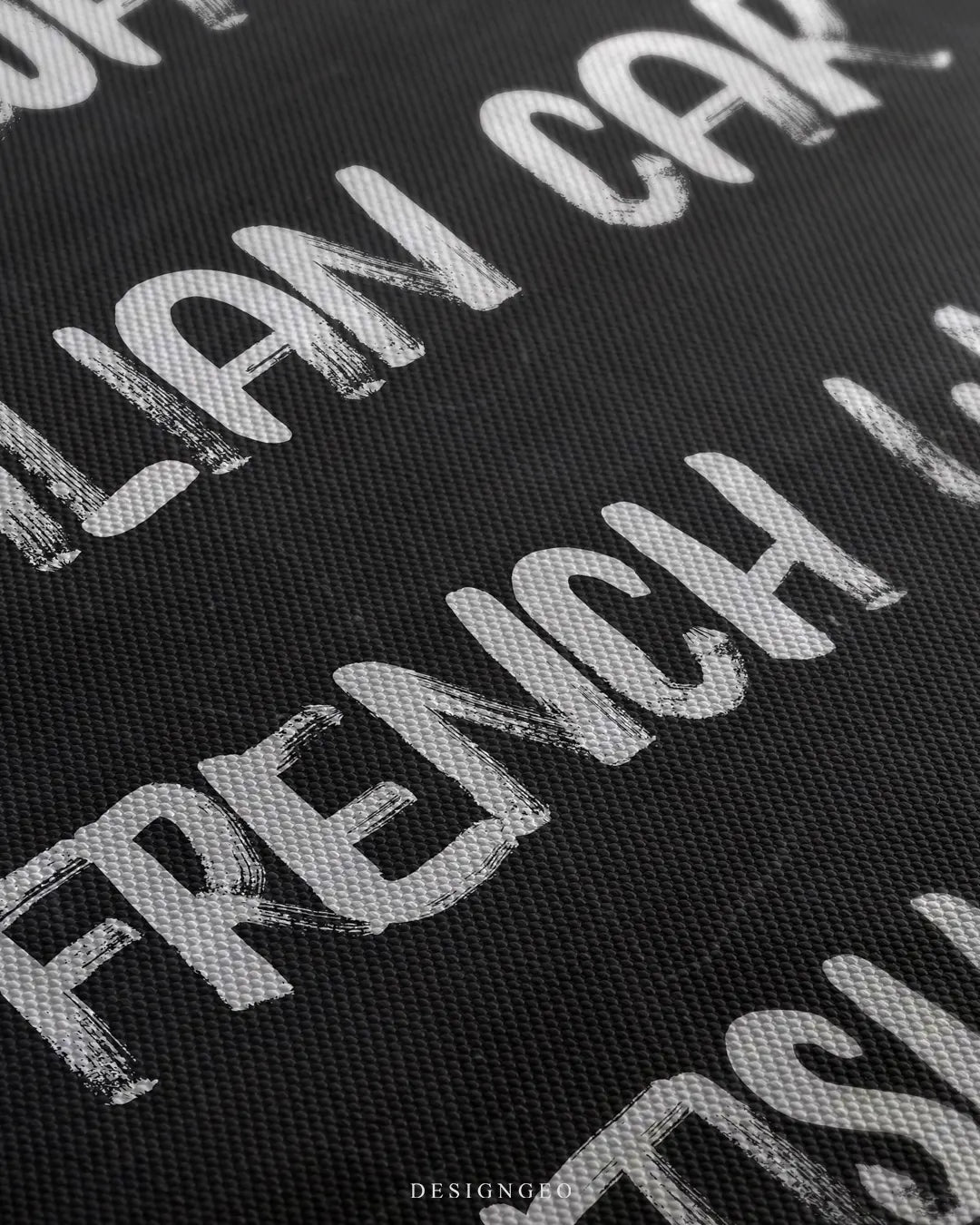 Angled close-up macro view showing the textured canvas grain and white chalk-style brushstrokes reading Italian Car and French Wine on black
