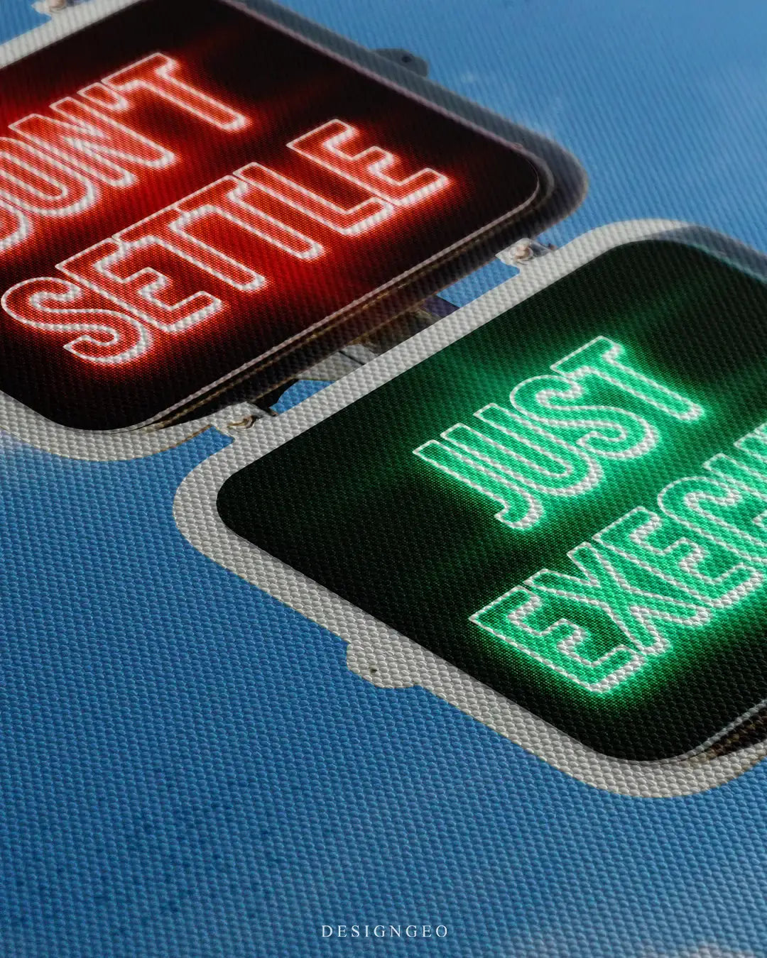 Close-up of modern financial wall art featuring a traffic light with "Don't Settle," and "Just Execute" motivational quotes on a serene blue sky background