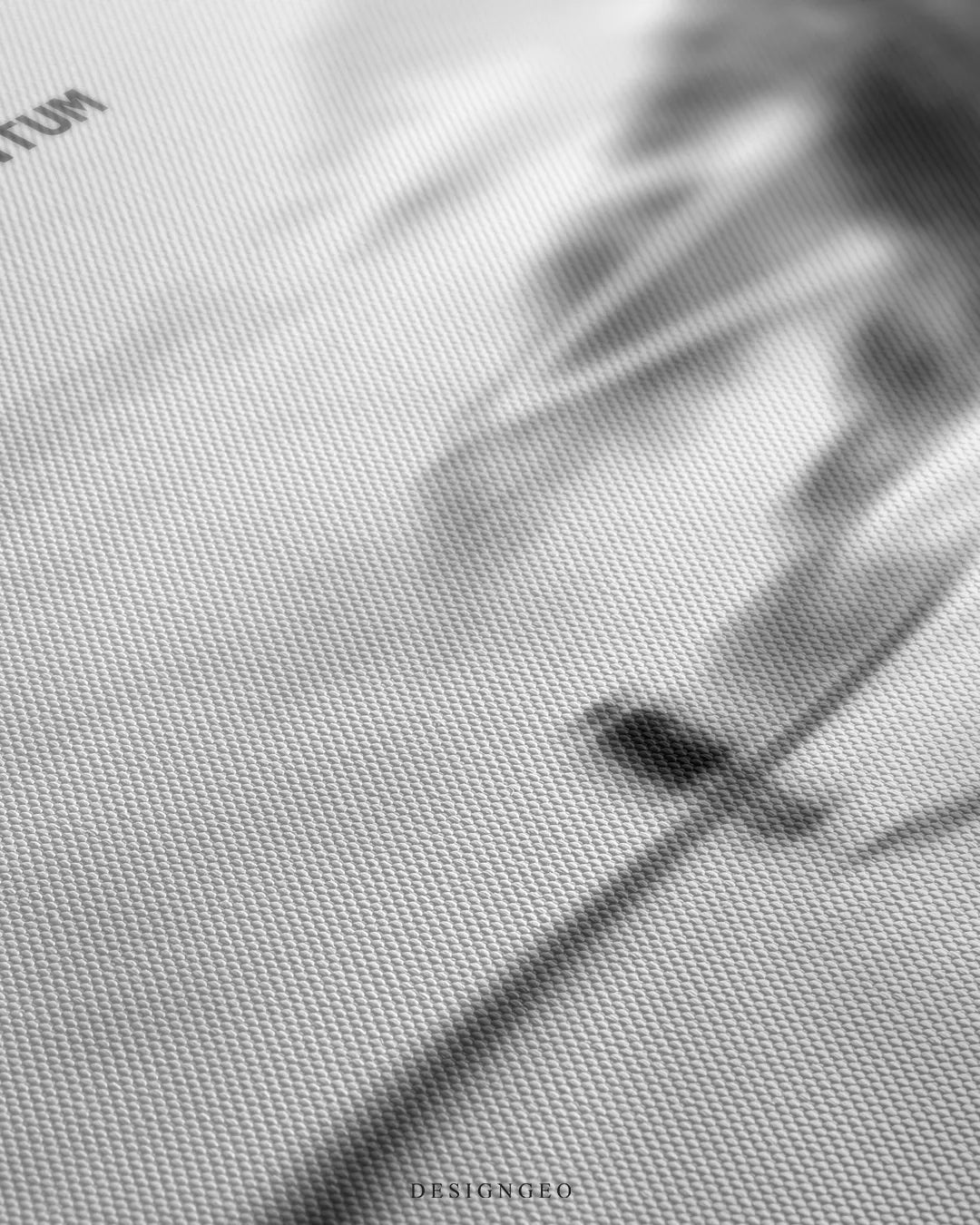 Angled detailed macro texture of fine woven white canvas print showing cyclist silhouette on winding road with Never Lose Momentum quote