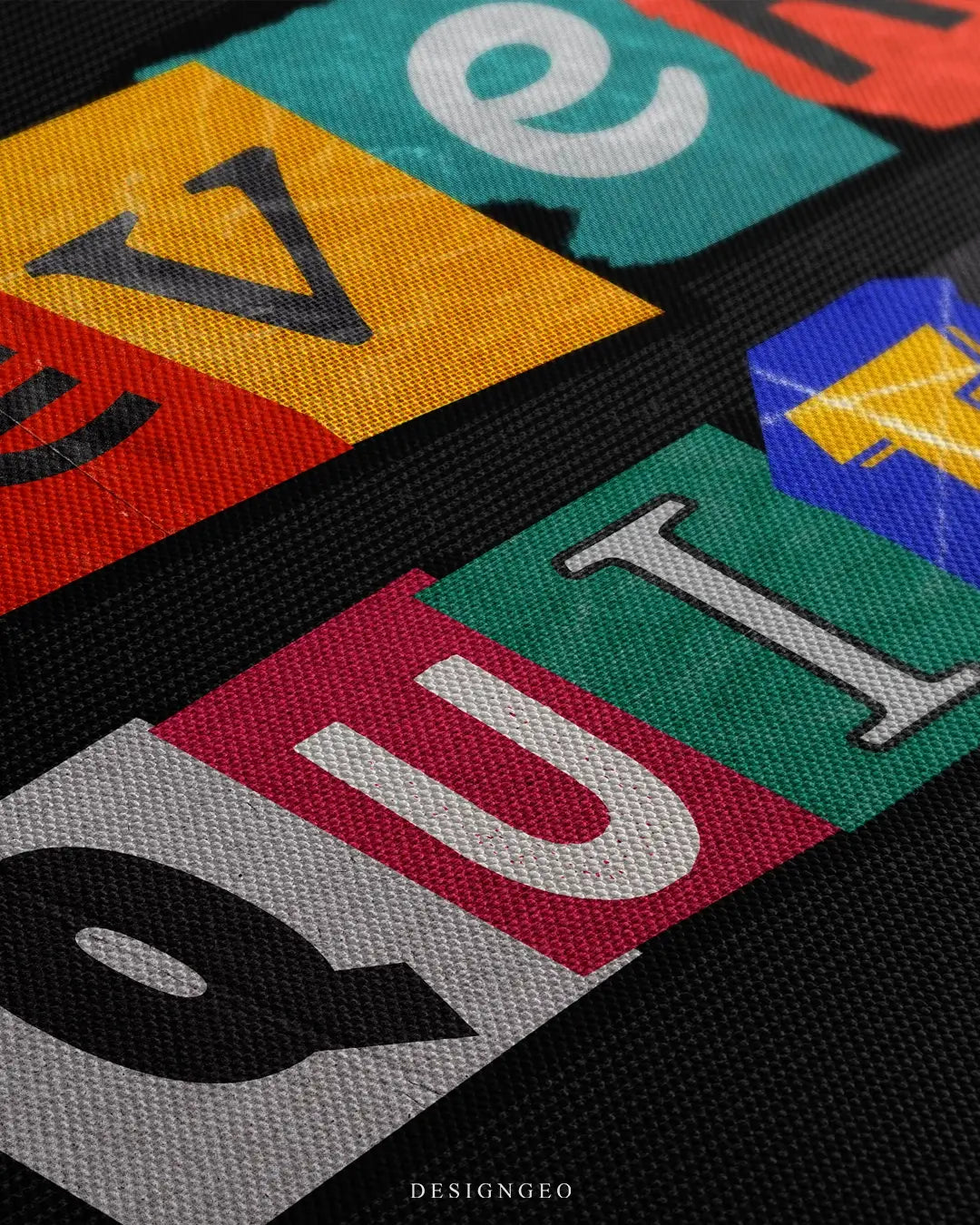 Close-up of motivational wall art featuring the "Never Quit" phrase in a bold, colorful font with artistic paint textures on a solid black background