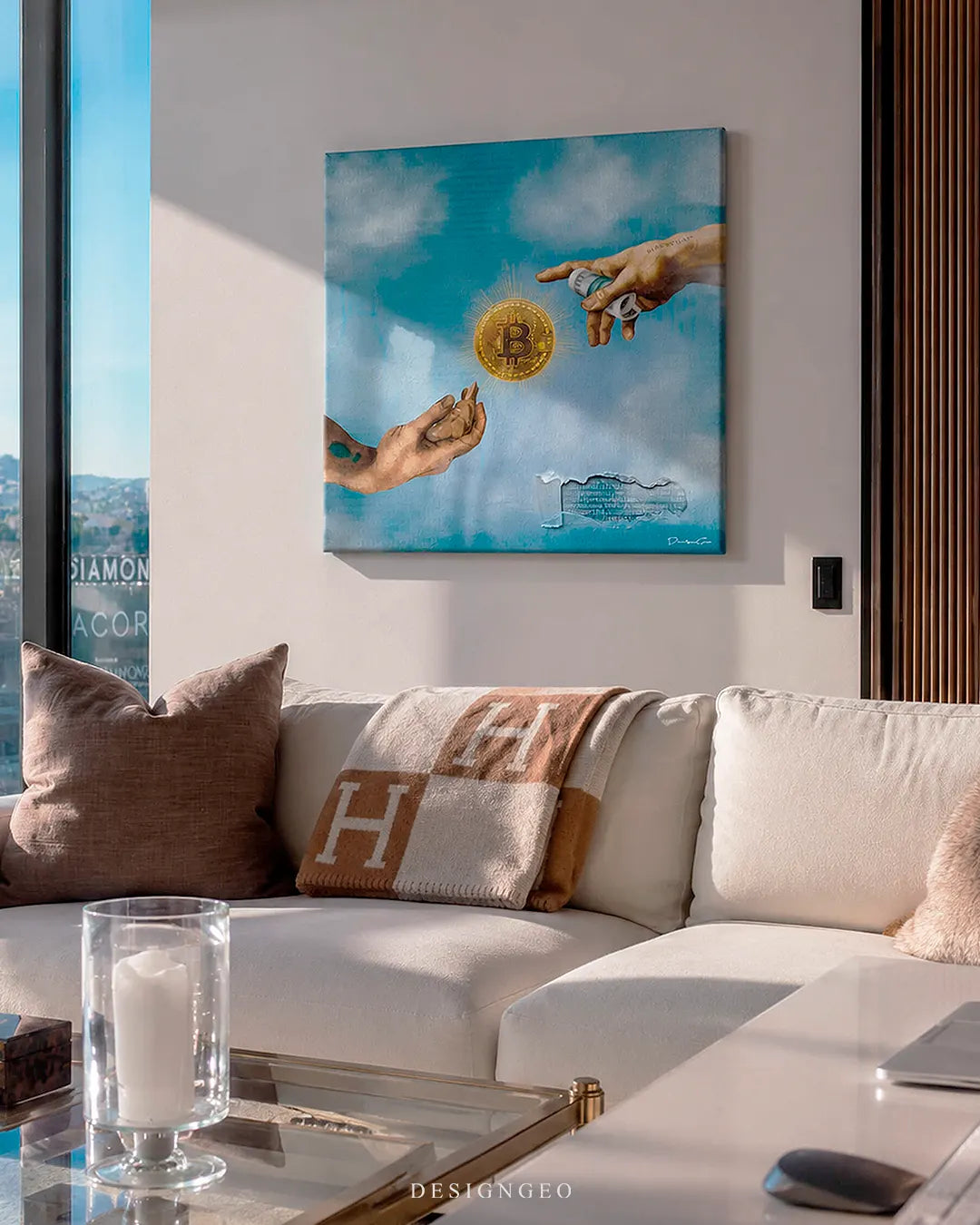 Square Creation of Bitcoin canvas print mounted on a white wall above a modern white sofa with a luxury brown throw blanket in a high-rise penthouse room