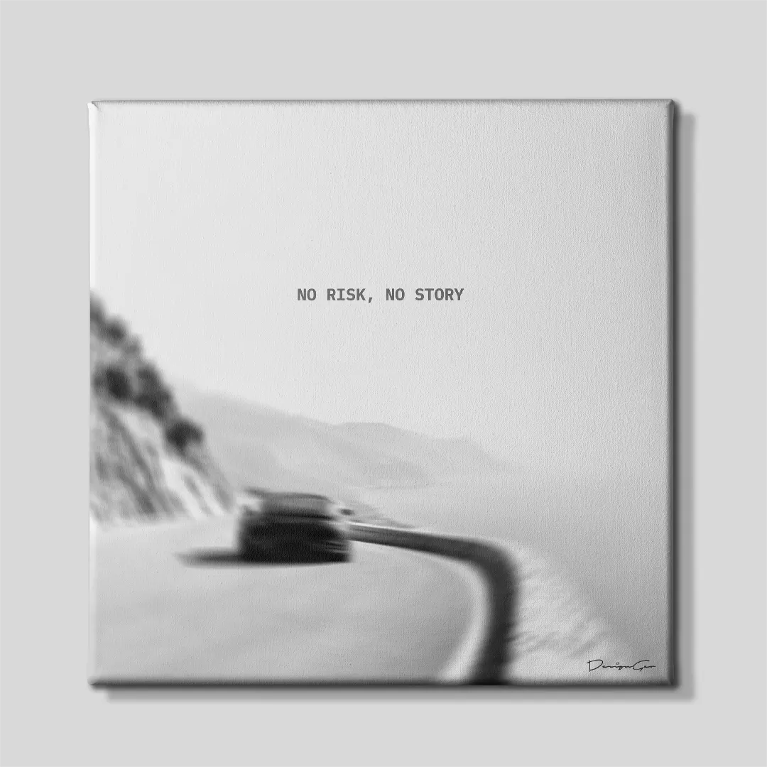 Black and white square canvas wall art featuring a sports car driving along a winding coastal mountain road under quote No Risk No Story 0.75 inch thin wrap