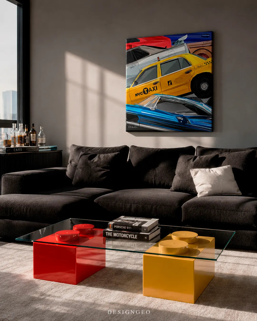 Vertical NYC Taxi canvas print mounted on a modern grey wall above a black sectional sofa and a glass coffee table with red and yellow Lego-style block bases