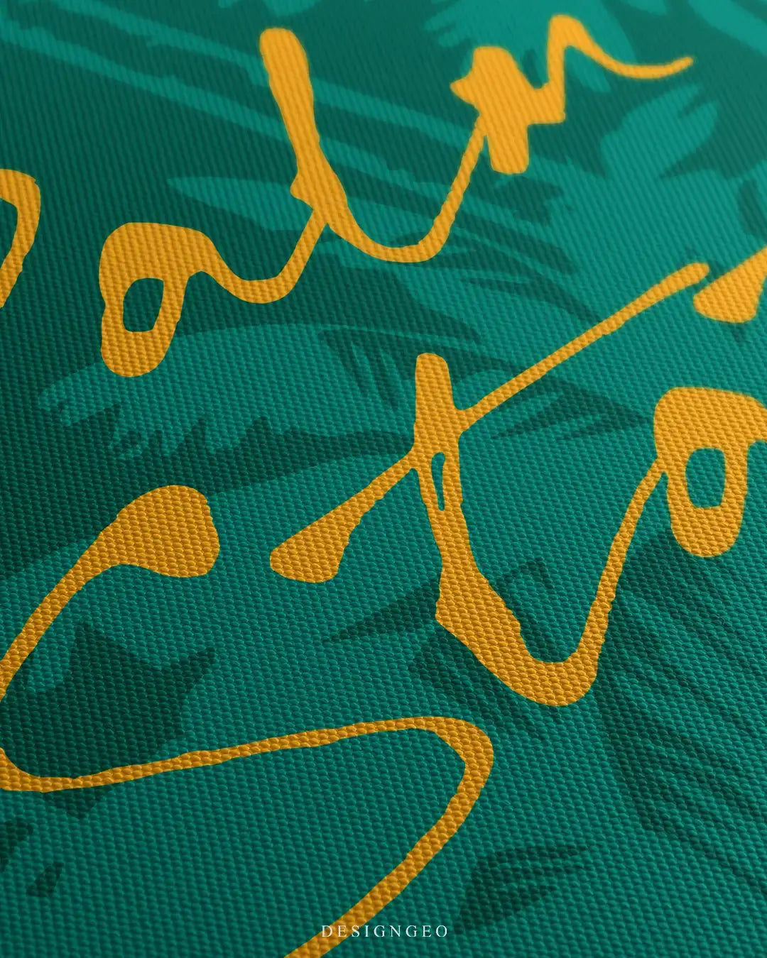 Close-up of modern luxury wall art featuring a motivational phrase in bold yellow typography with palm tree silhouettes over an abstract emerald green background