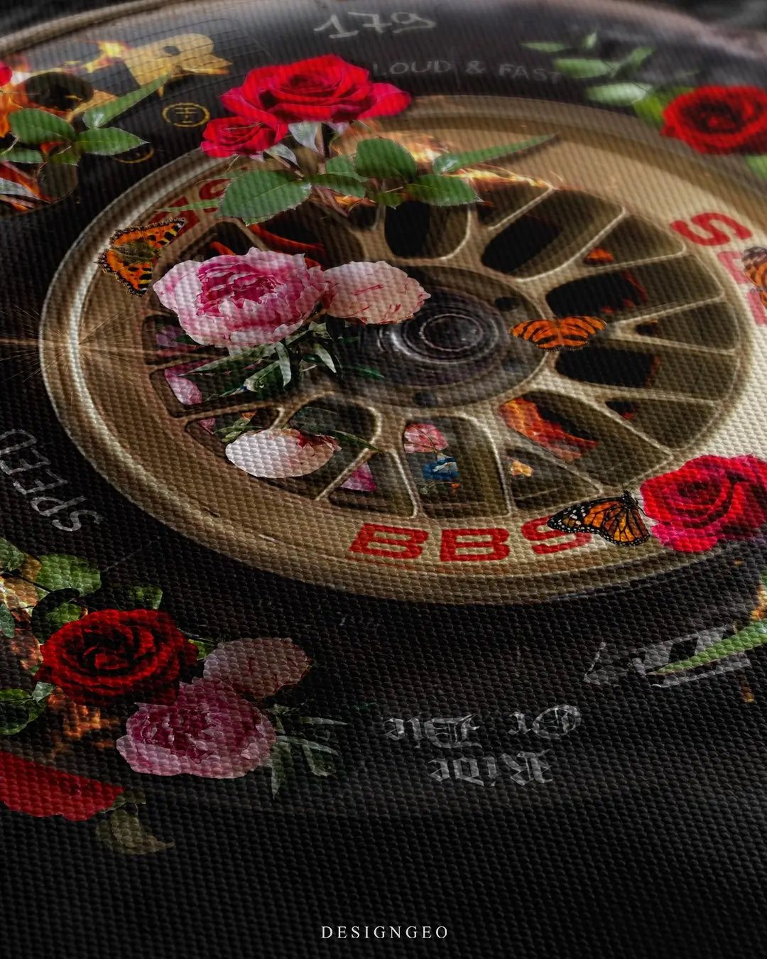 Close-up of automotive motivation art showing a car wheel with realistic rubber textures, vibrant orange flames, and delicate flowers among smoke