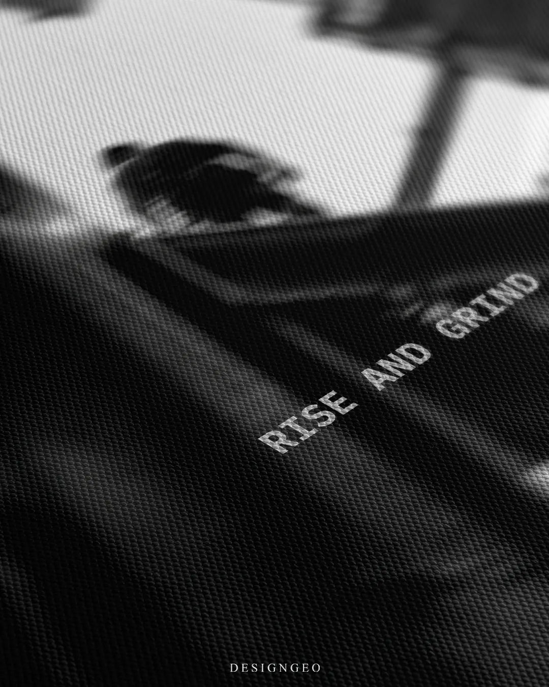 Angled detailed macro texture of fine woven canvas print showing construction worker silhouette on steel beam with Rise And Grind quote