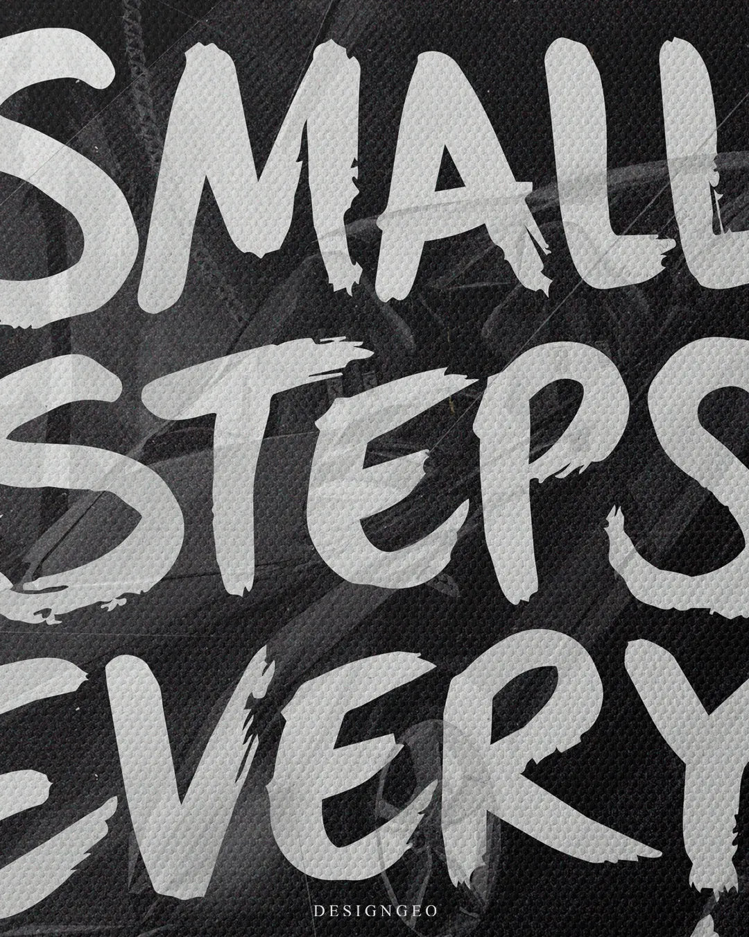 Close-up macro view highlighting the white street-art style typography spelling "SMALL STEPS EVERY" on a textured black matte canvas print background