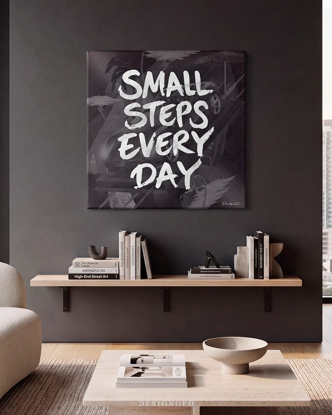 Modern interior lounge featuring the square "SMALL STEPS EVERY DAY" graffiti canvas print mounted on a dark charcoal wall above a wooden floating shelf with books