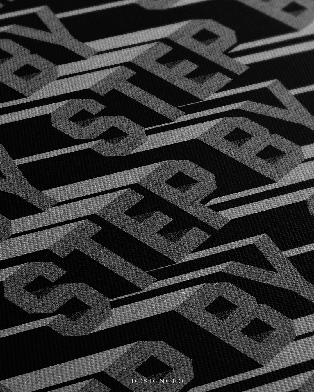 Angled close-up detail shot highlighting the textured grey 3D typography, deep drop shadows, and fine woven canvas fabric grain