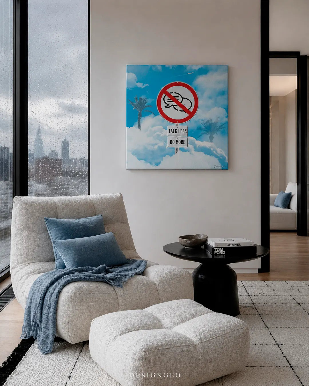 Modern luxury apartment room setup featuring a white lounge chair and a square canvas print with a Talk Less Do More street sign set against a cloudy blue sky background