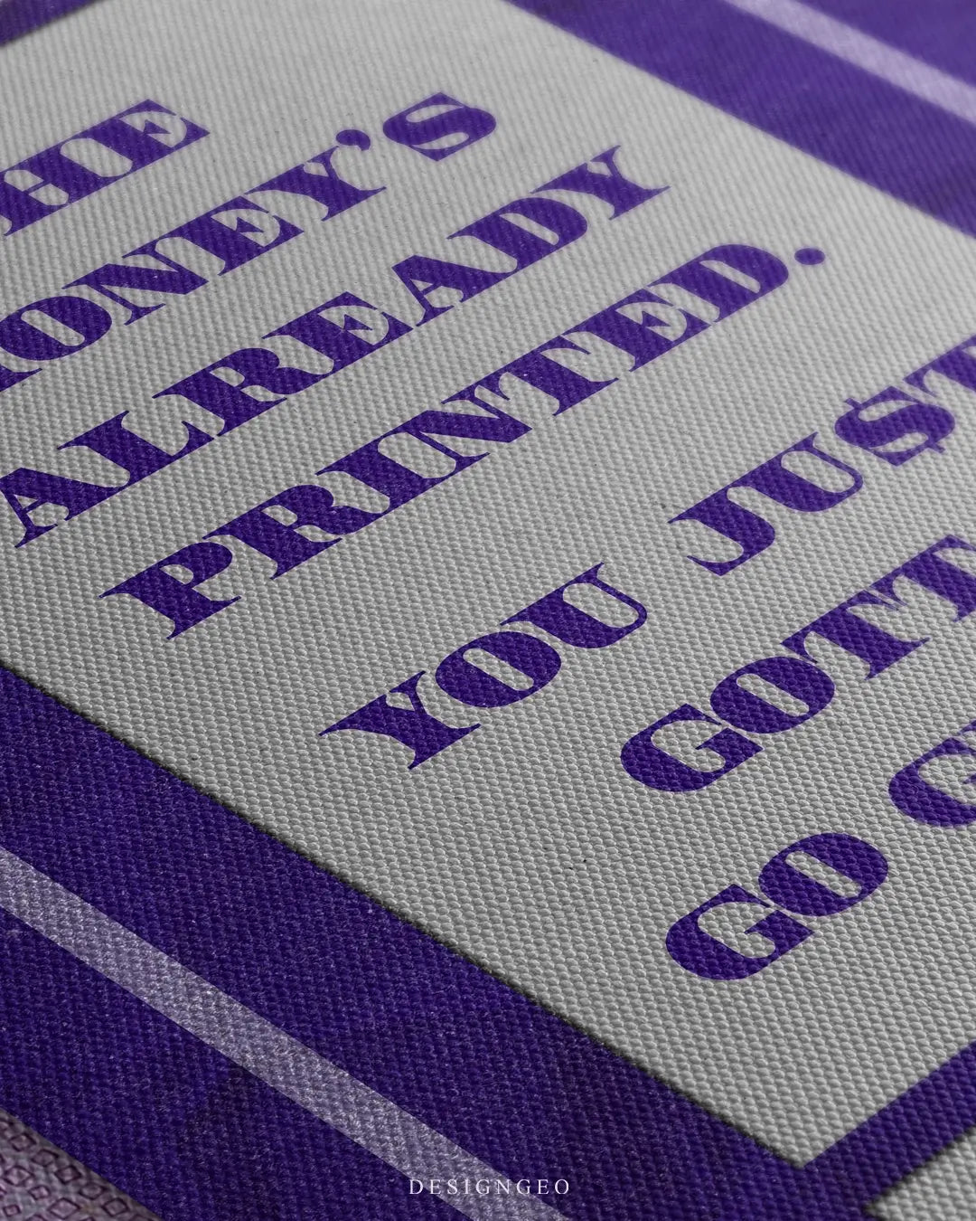 Close-up of motivational money art featuring a thick stack of Euro (EUR) banknotes with the phrase "The money is already printed" in bold violet typography on a white background