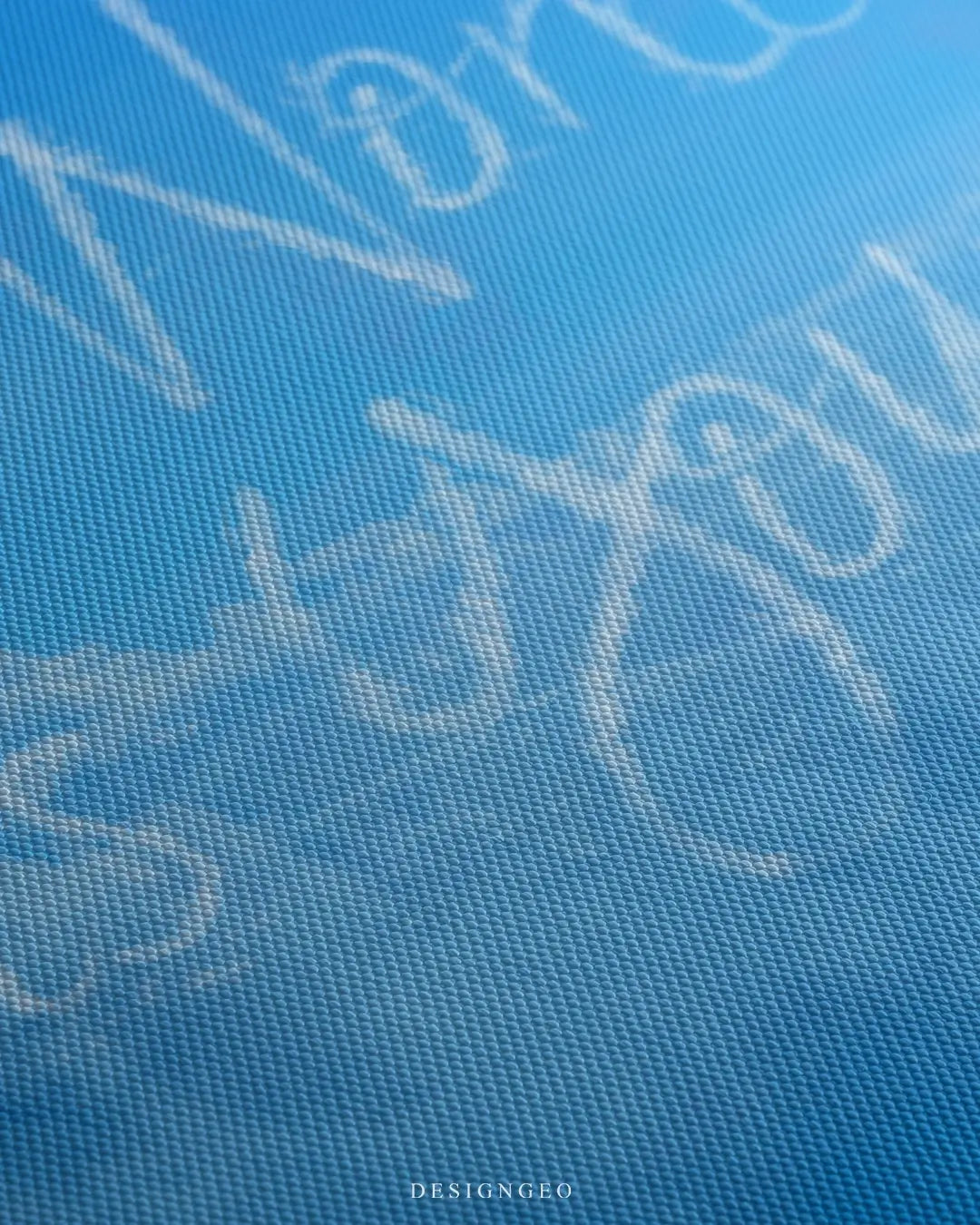 Close-up of modern motivational wall art featuring the phrase "The World is Yours" written in fluffy white clouds across a clear light blue sky