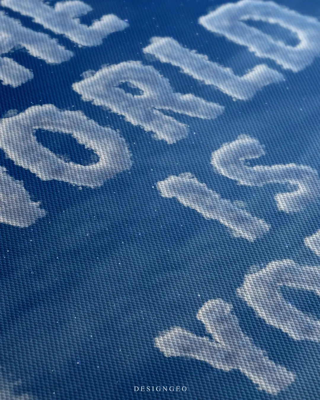 Close-up of modern motivational wall art featuring fluffy white clouds forming the phrase "The World is Yours" against a deep blue sky