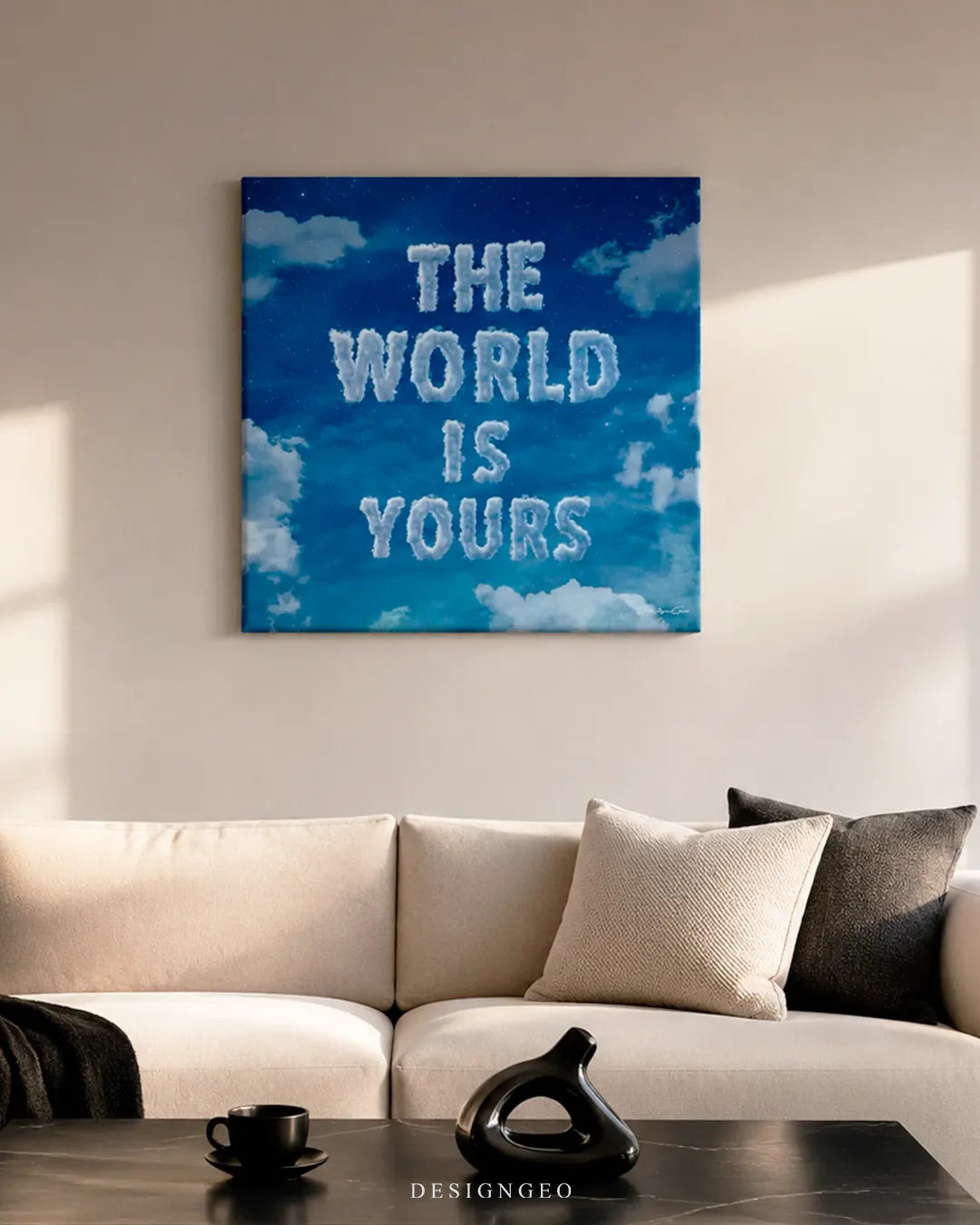 Square blue sky The World Is Yours cloud canvas wall art mounted above a beige modern sofa with throw pillows in a sunlit living room