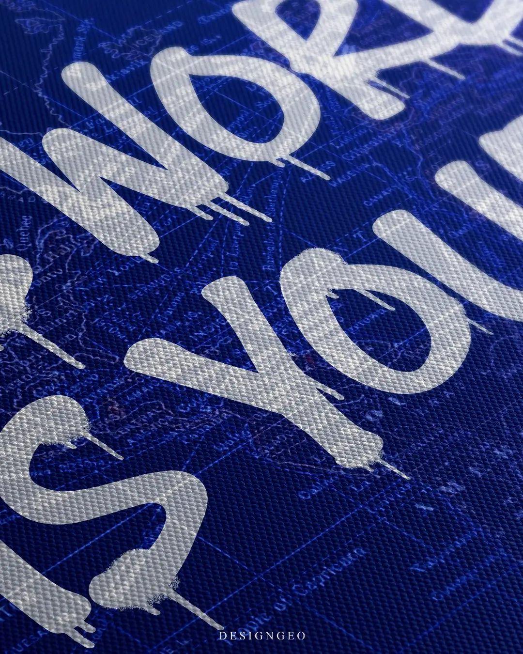 Close-up of modern motivational wall art featuring the quote "The World is Yours" in a white street-style graffiti font on a deep royal blue background