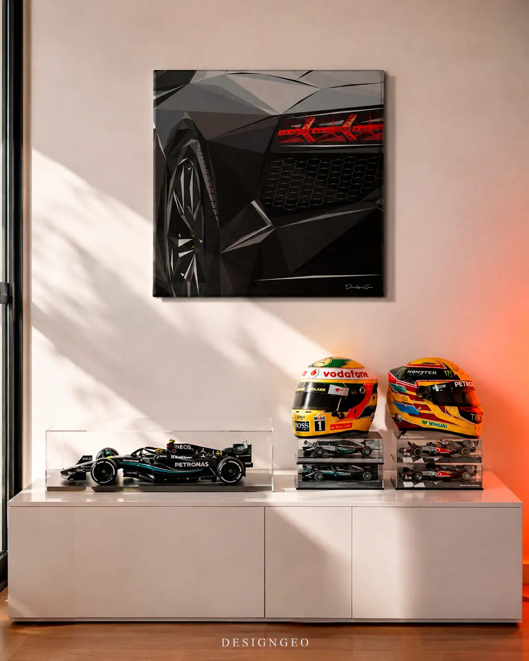 Square black exotic supercar canvas print mounted on a beige wall above a white credenza displayed with F1 race car scale models and replica racing helmets