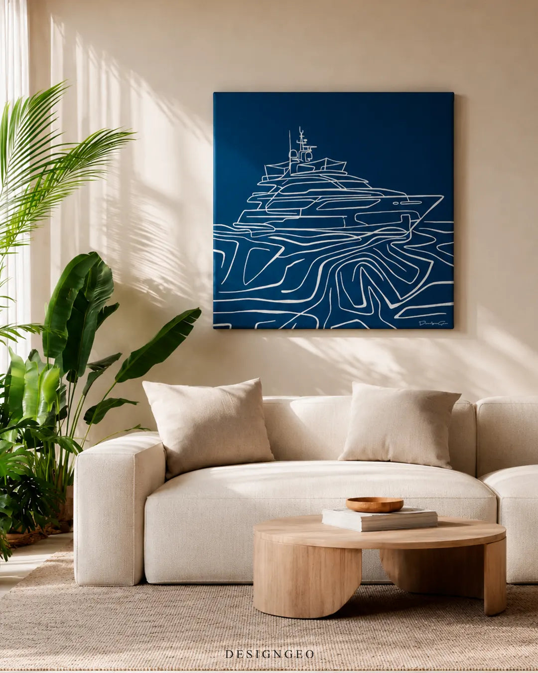 Bright modern living room setup with the square navy blue yacht canvas art mounted above a beige sectional sofa, low wooden coffee table, and indoor palm plant