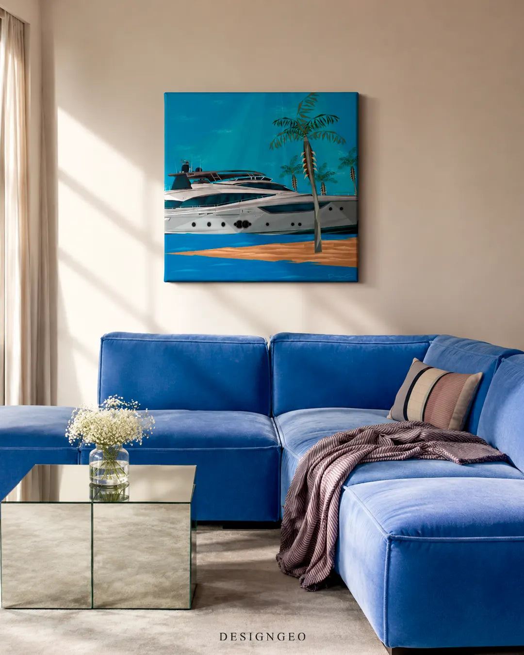 Square luxury yacht canvas print displayed on a beige wall above a royal blue velvet sectional sofa and mirrored glass coffee table