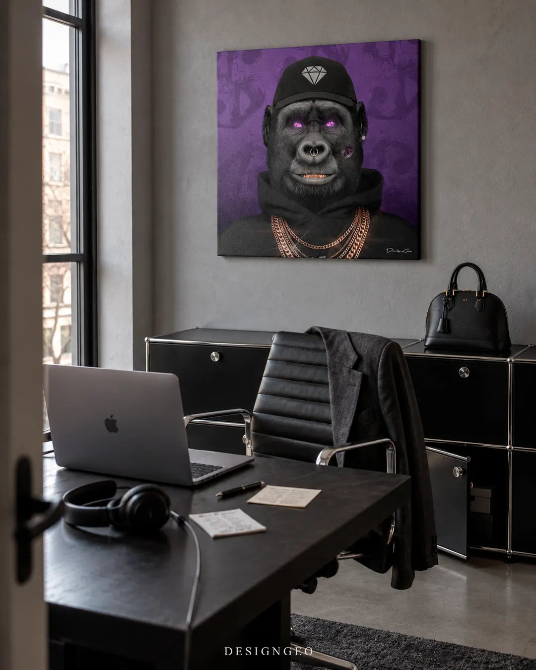 Modern luxury home office featuring a square canvas print of a gorilla in a black hoodie, diamond hat, and gold chains mounted on a grey wall above a sleek black executive desk