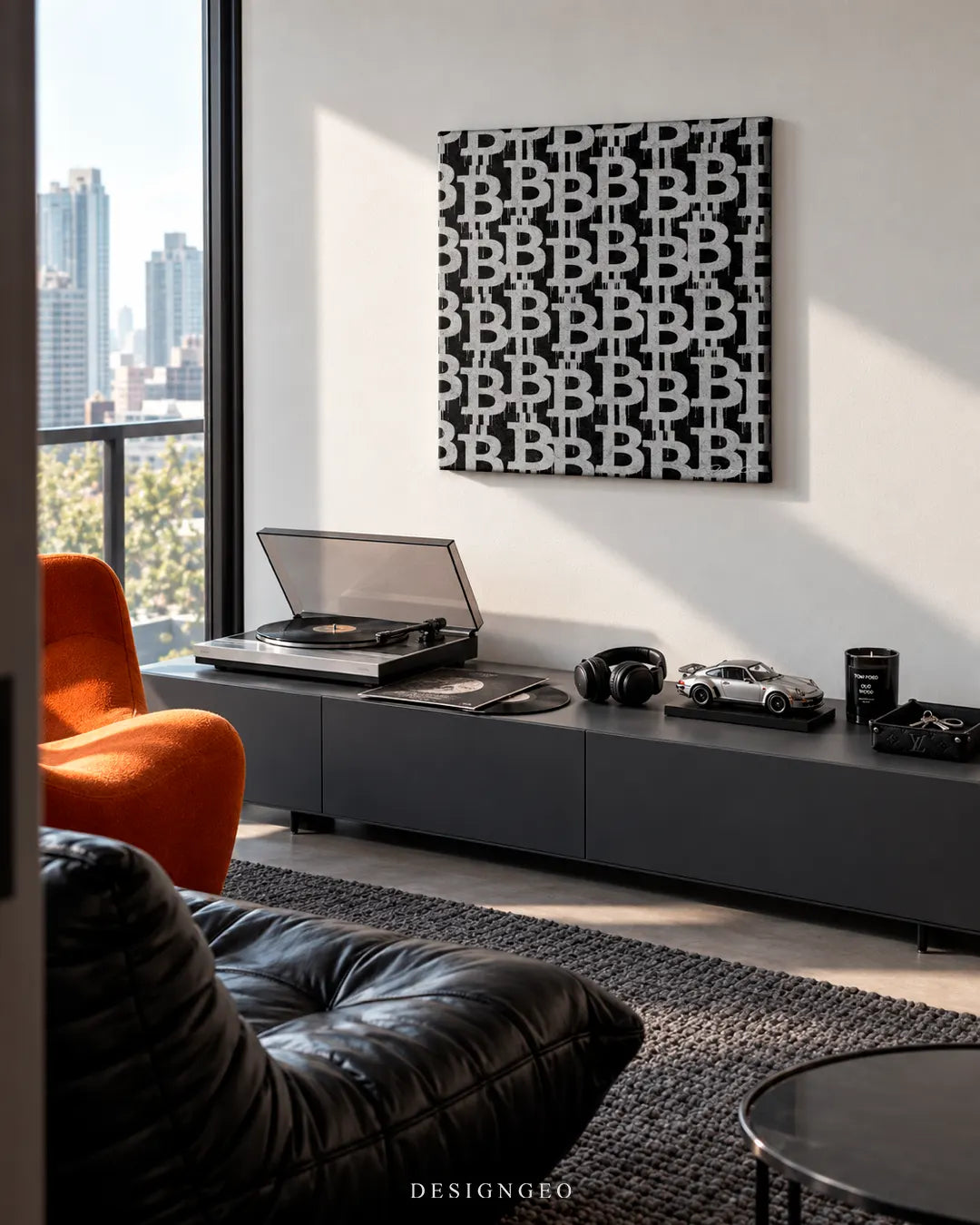 Modern penthouse living room featuring a square crypto canvas print of a black and white spray-painted Bitcoin logo pattern mounted on a light wall above a dark media console with a record player