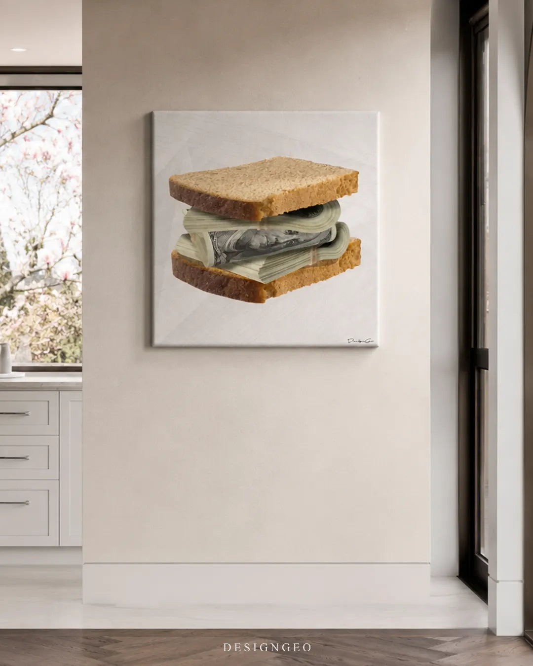Square money sandwich canvas wall art mounted on a beige column wall in a modern bright kitchen near white cabinetry and large windows