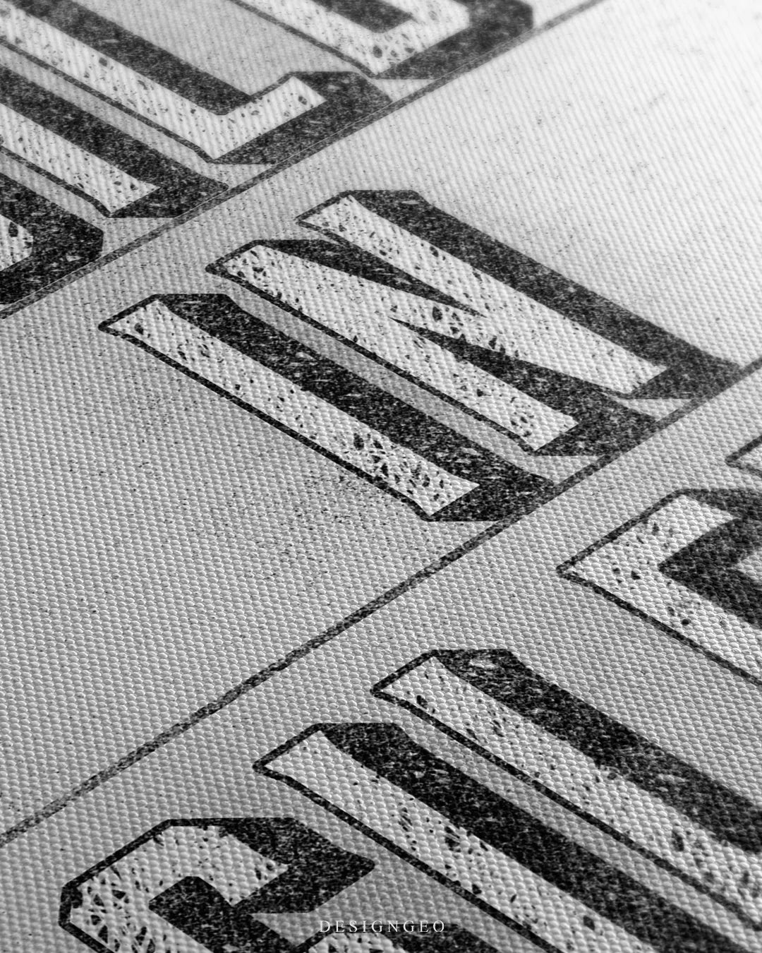 Angled close-up detail shot highlighting the woven canvas fabric grain and distressed 3D drop-shadow effects on the lettering