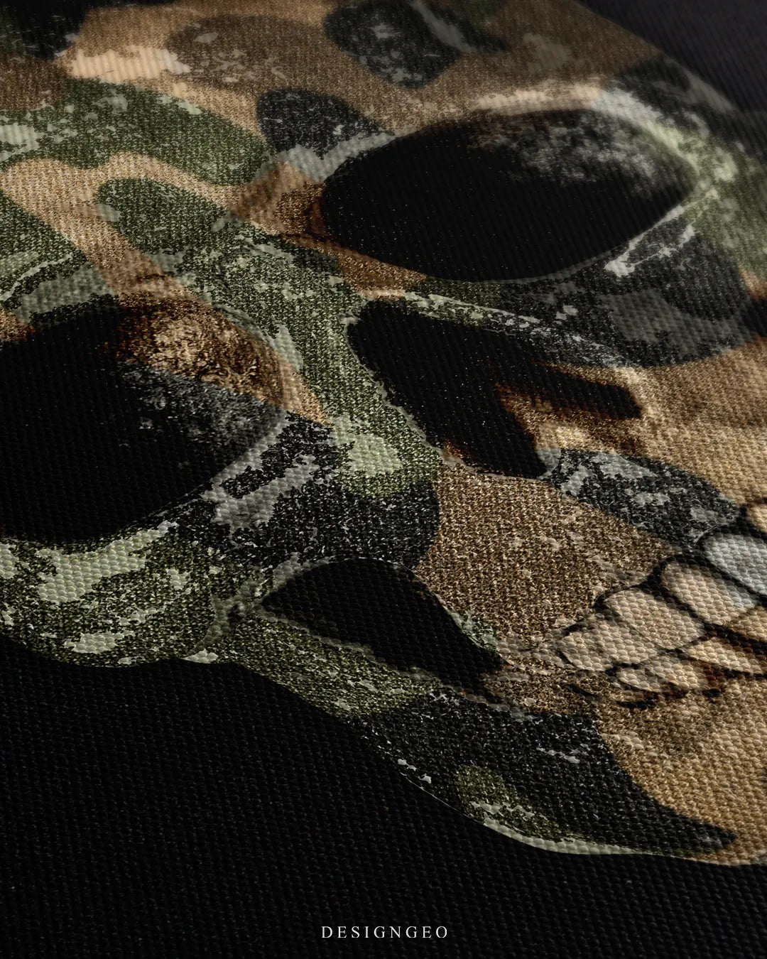 Angled extreme macro view highlighting the woven canvas surface texture, green and beige camo pattern contrast, and anatomical skull jawline shading