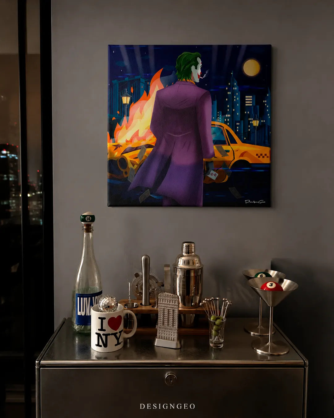 Square Clown canvas print mounted on a dark wall above a metallic bar cart with an I Love NY mug, martini glasses with billiard balls, and a cocktail shaker