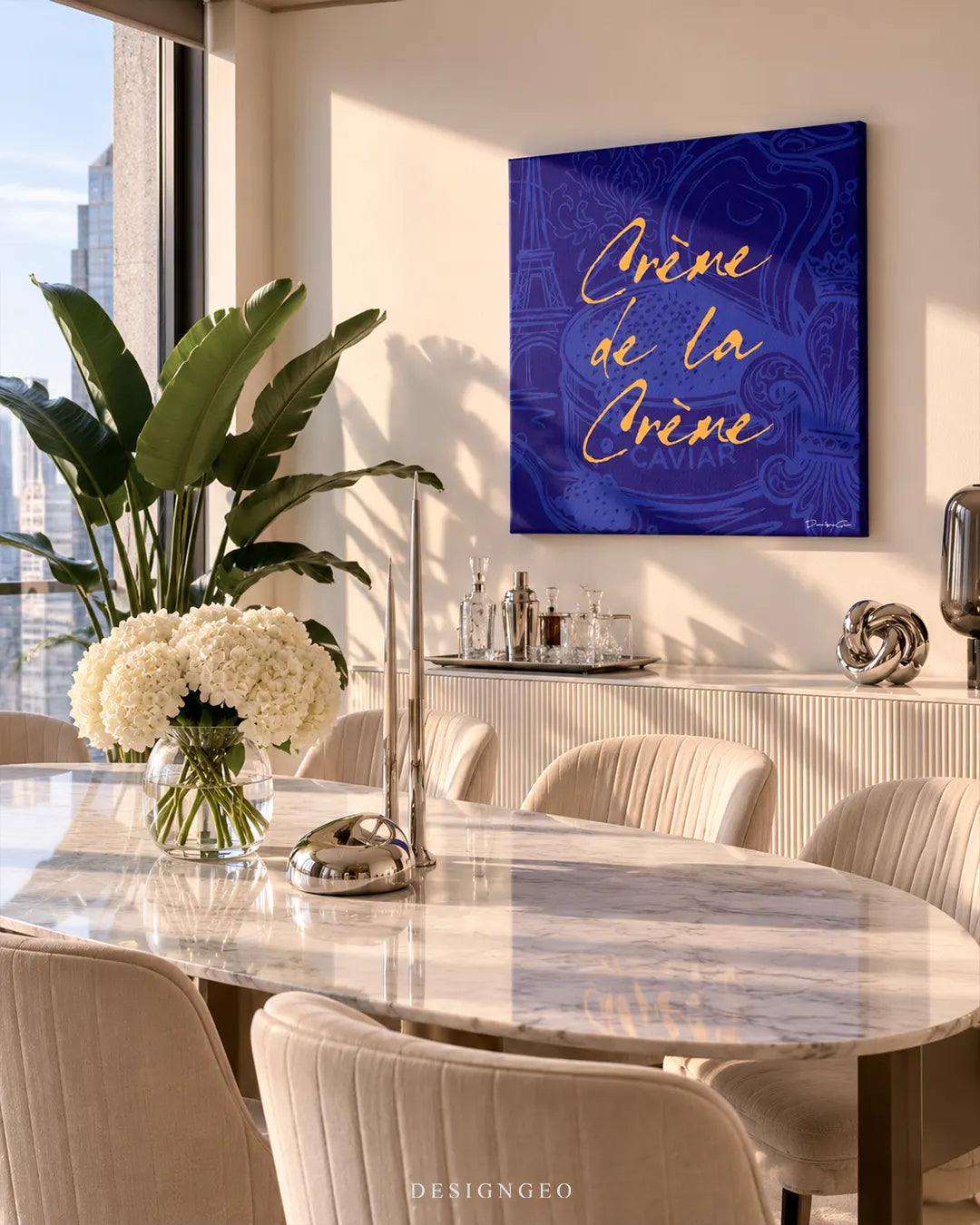 Front view of a square luxury typography canvas print featuring yellow gold cursive calligraphy spelling Crème de la Crème Caviar over a royal blue background with Eiffel Tower and Fleur-de-lis sketches