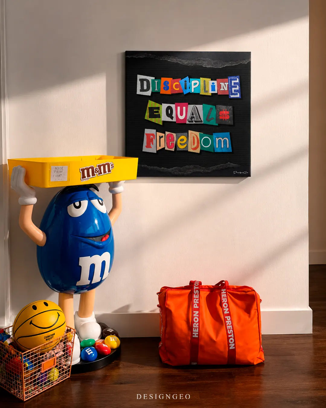 Modern pop art interior setup displaying a square canvas print with the phrase DISCIPLINE EQUALS FREEDOM in colorful ransom note cutout letters against a black background