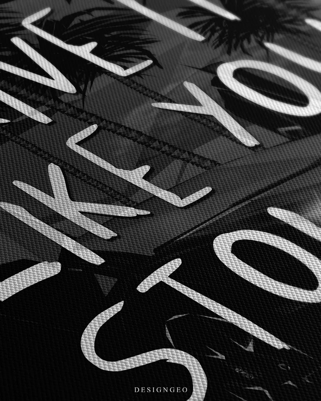 Angled detailed macro texture of dark woven canvas print showing white brush lettering reading Drive It Like You Stole It over supercar background