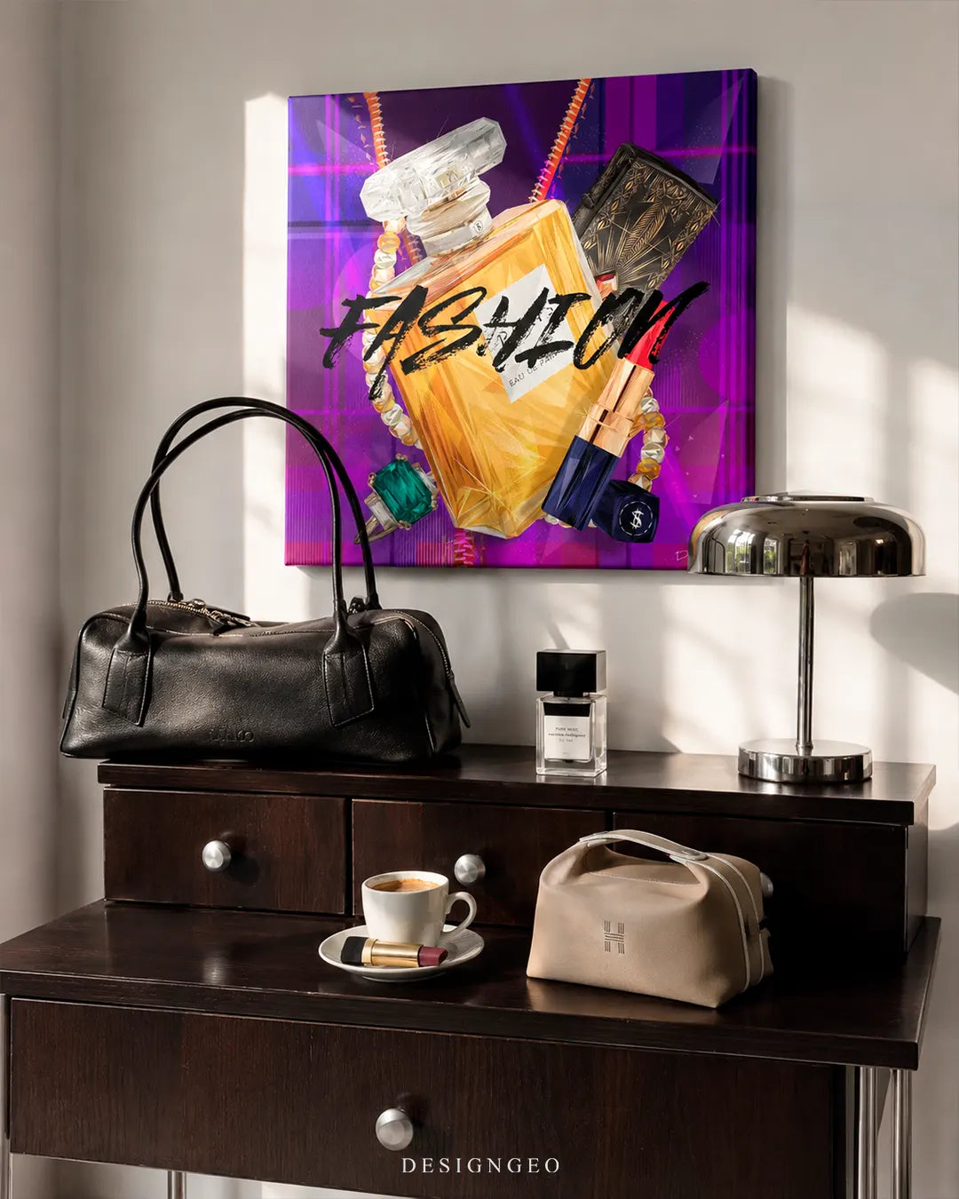 Square purple fashion perfume canvas print mounted on a white wall above a dark wooden vanity dresser with a black leather handbag, chrome desk lamp, and perfume bottles