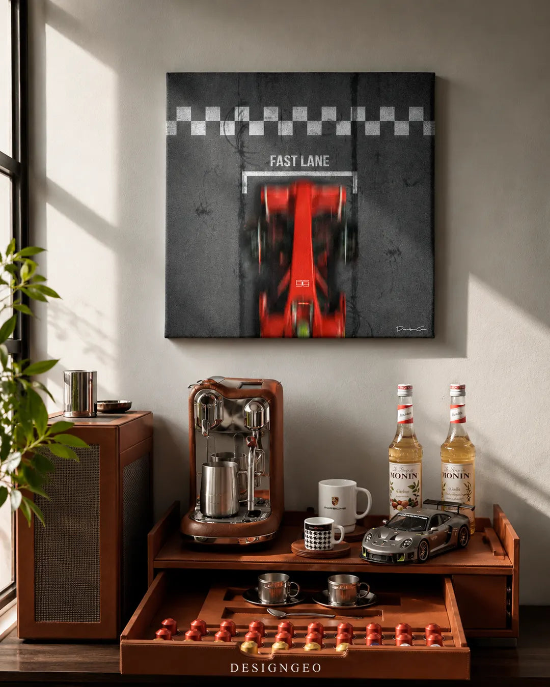 Square Fast Lane red racing car canvas print mounted on a gray wall above a leather espresso coffee bar with a Porsche mug, model car, and Monin syrup bottles