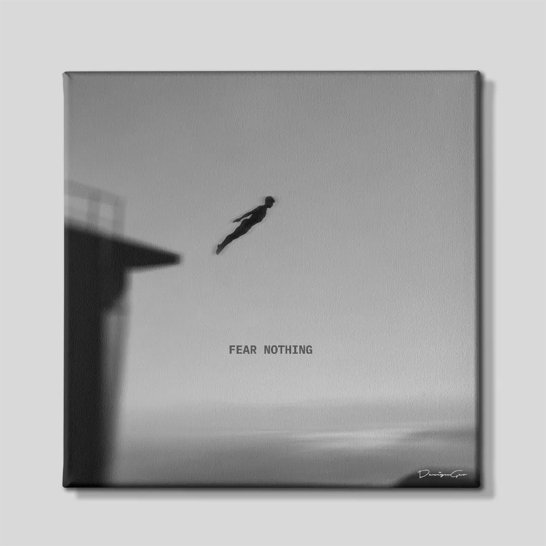 Black and white square canvas wall art featuring a high cliff diver silhouette leaping off a platform above the ocean under motivational quote Fear Nothing 0.75 inch thin wrap