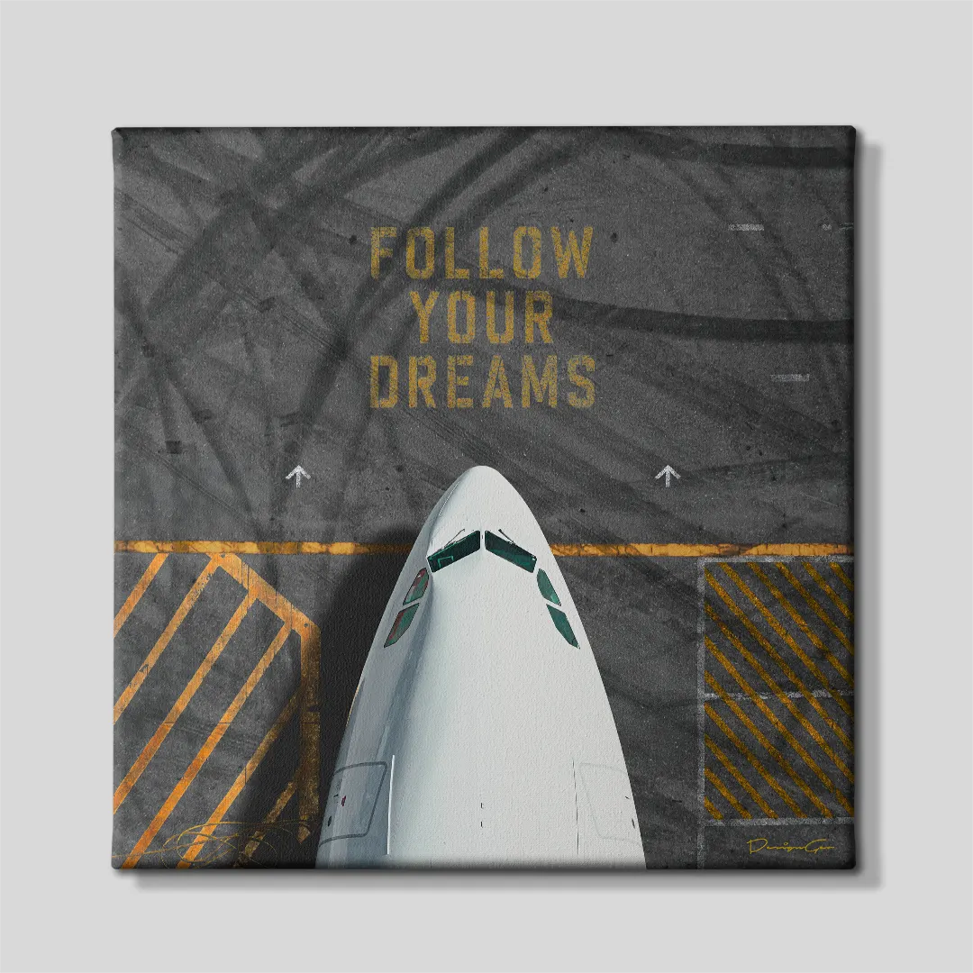 Front view of a square aviation canvas print featuring the nose of a white airplane on an asphalt runway with yellow markings and the phrase "FOLLOW YOUR DREAMS" in yellow stencil font