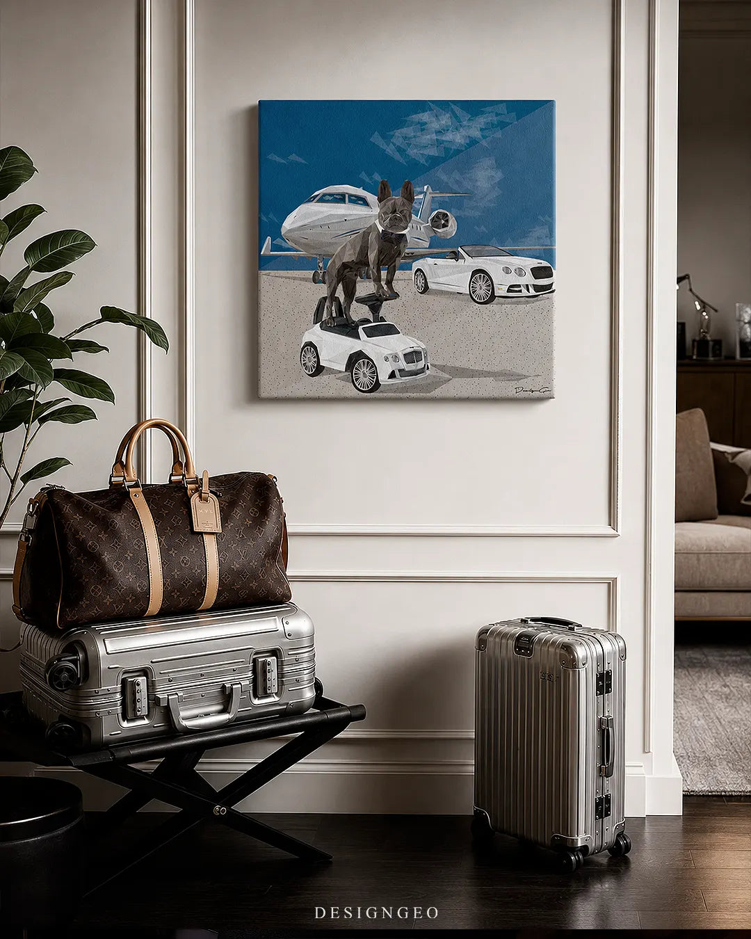 Square French bulldog private jet canvas wall art mounted on a cream wainscoted wall in a luxury foyer next to aluminum luggage and a designer travel duffel bag